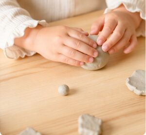 粘土で丸を作ろうとしている子どもの手元