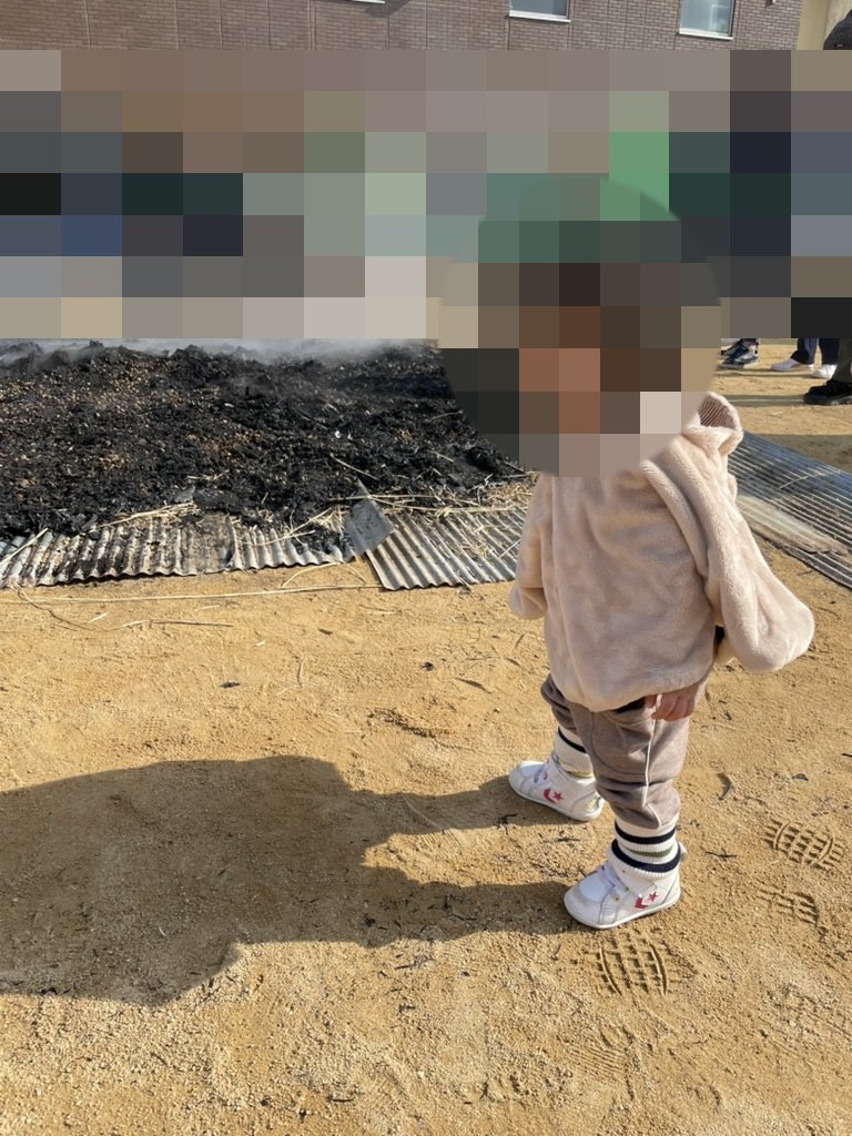 どんど焼き会場に立つ1歳児