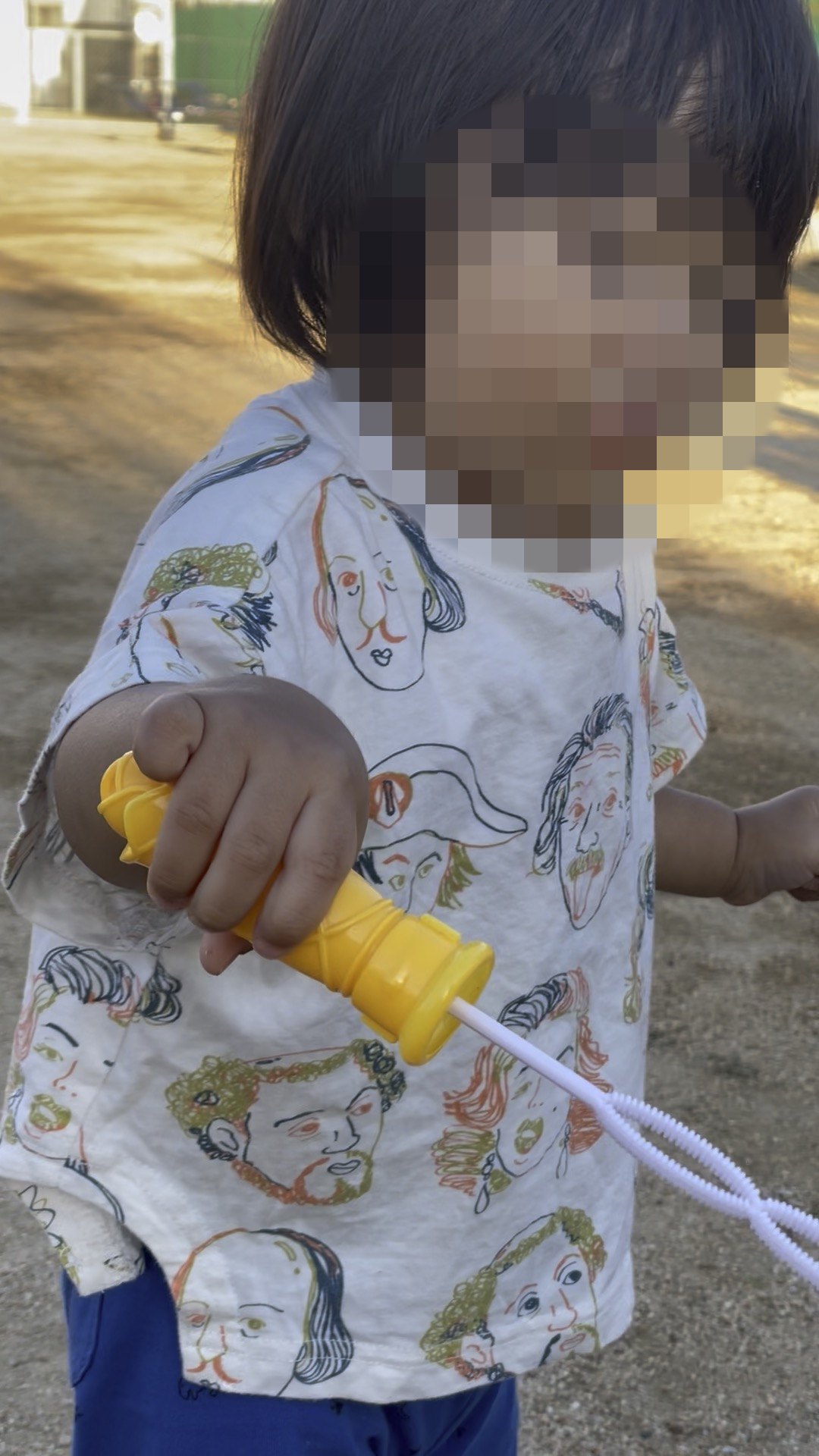 シャボン玉の道具を手に持つ1歳児