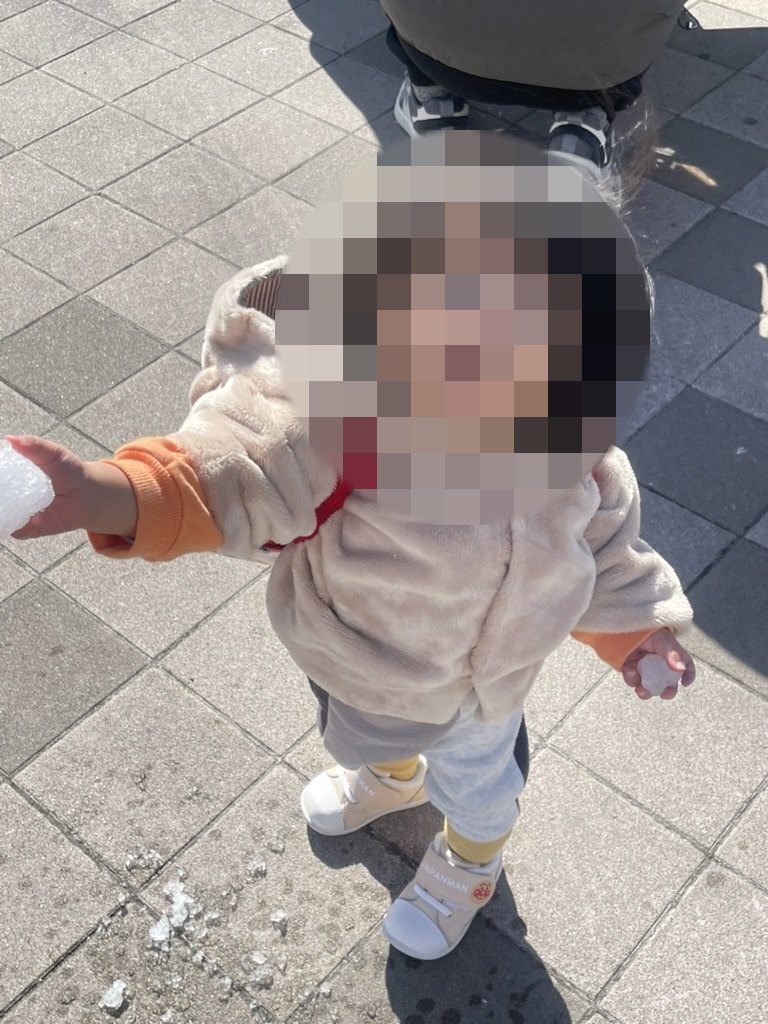手に雪を持つ1歳児