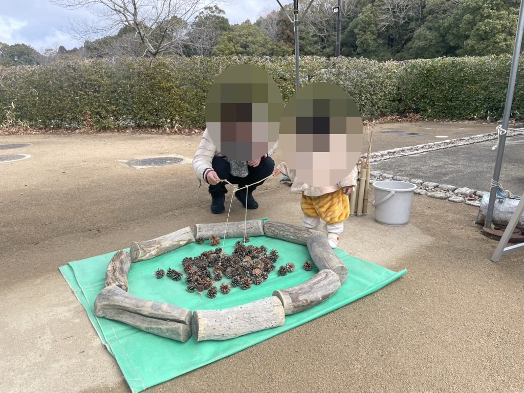 松ぼっくりを使った里山の遊びに参加する1歳児