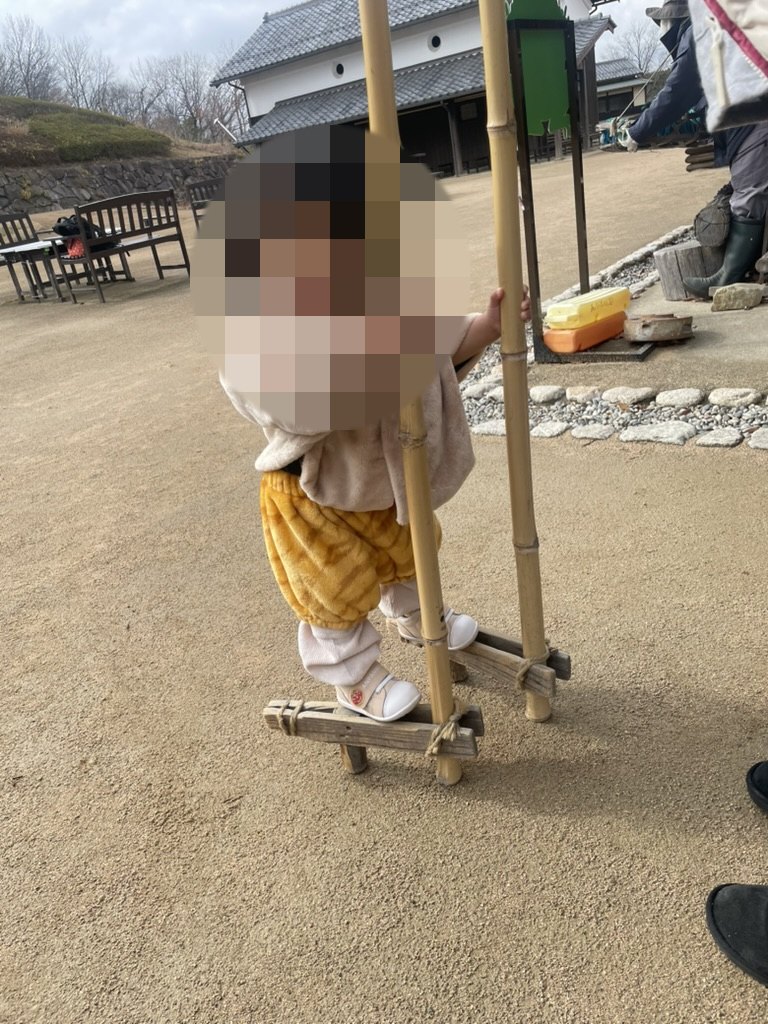 里山活動で竹馬に触れる1歳児